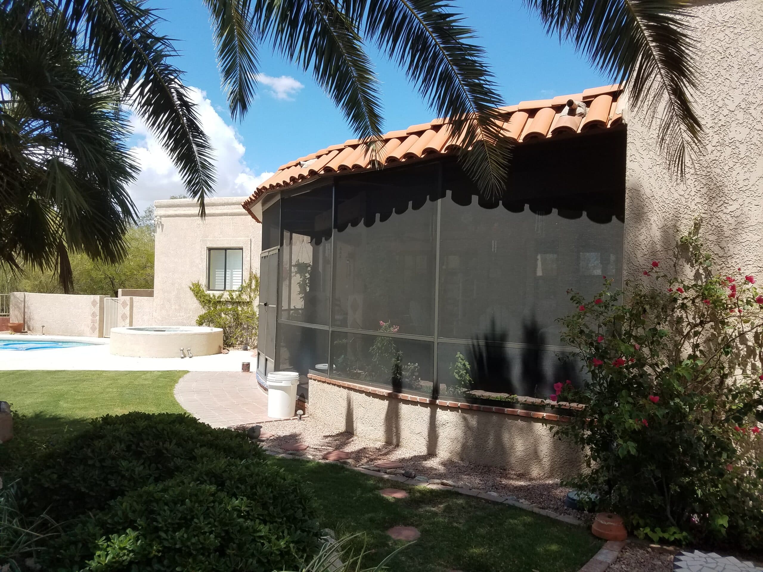 Aluminum-framed enclosure surrounded by lush backyard greenery at a Tucson, AZ home