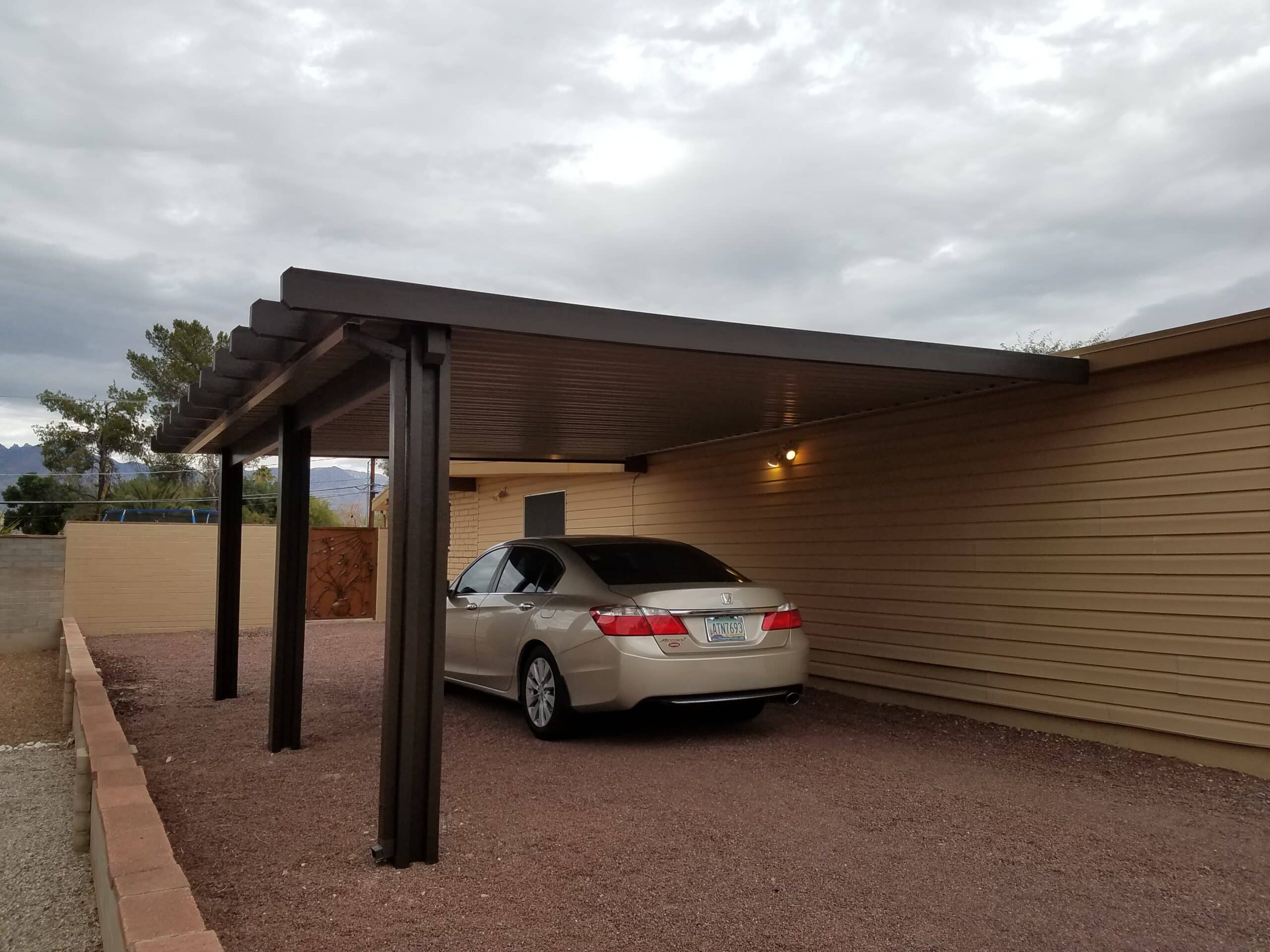 Brown aluminum attached awning providing shade over a patio on a Tucson, AZ home